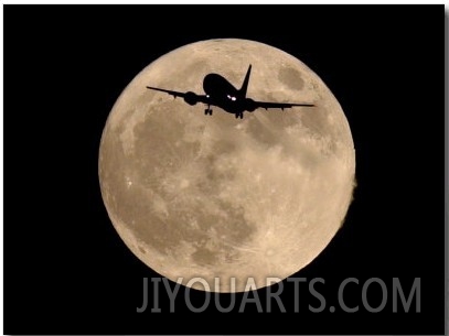 An Airliner is Silhouetted against a Full Moon