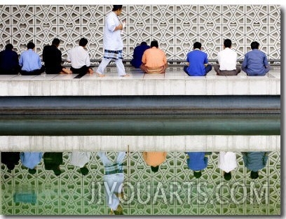 With the Water Reflection, a Muslim Man Walks Past Others Offering the Friday Prayer at a Mosque