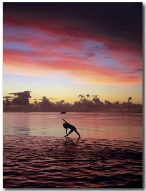 Woman Doing Yoga by Ocean at Sunset
