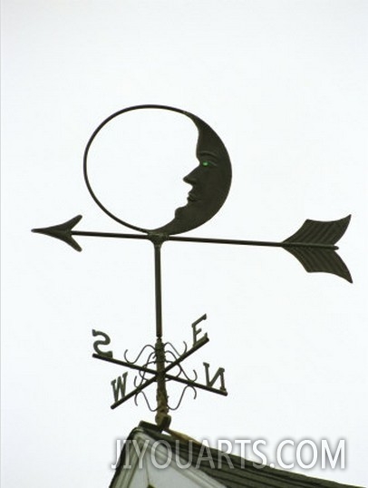 A Man In The Moon Weather Vane on a Roof Top