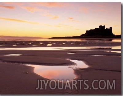 Bamburgh Castle in Silhouette at Sunrise, with Rock Pools on Empty Beach, Northumberland, England