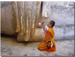 Novice Buddhist Monk Kneeling Beneath the Phra Atchana Buddha Statue, Sukhothai Province, Thailand